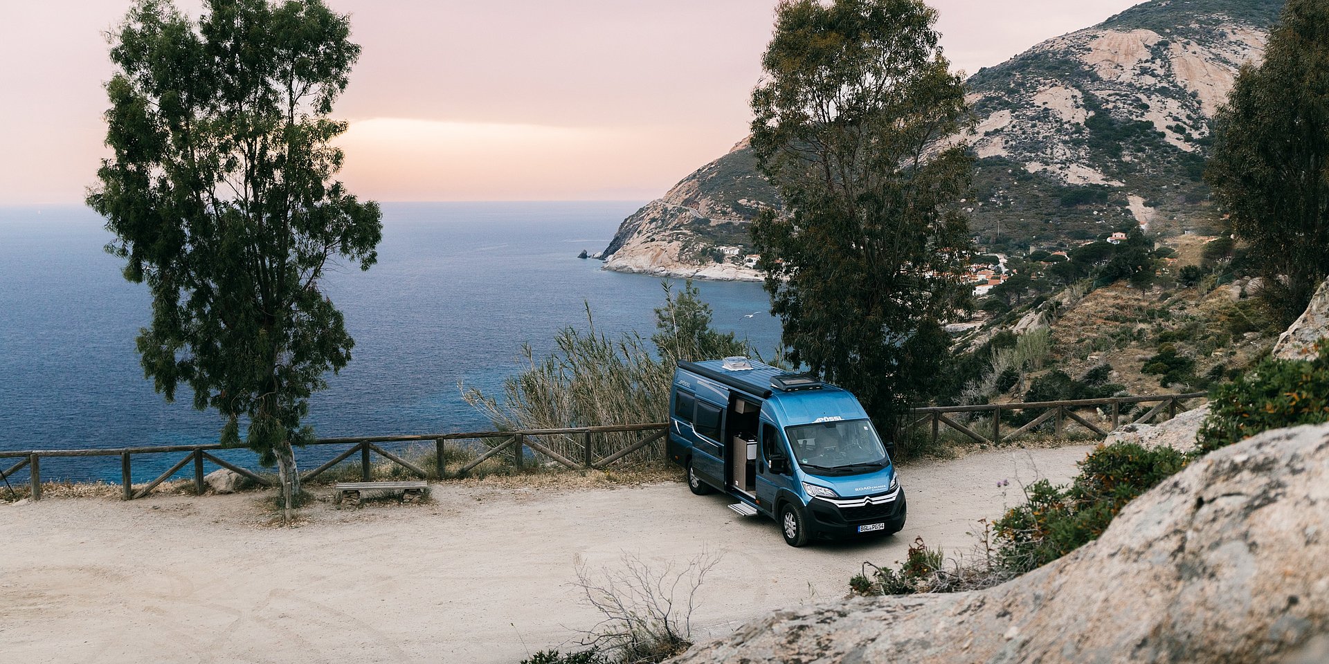 Ein Camper-Van parkt an der mediterranen Küste.