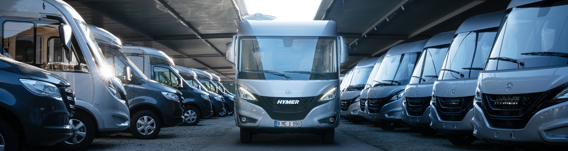Mehrere HYMER Wohnmobile stehen in einer Halle.